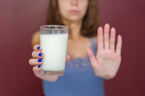 Woman with Milk Glass Holding Hand to Stop